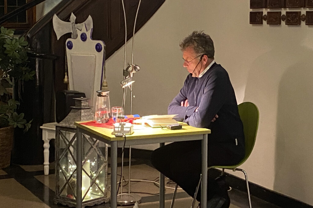 Richard Brandes sitzt an einem Tisch und liest